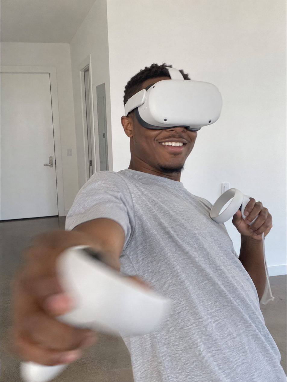 A smiling VR player reaching toward the camera with a controller